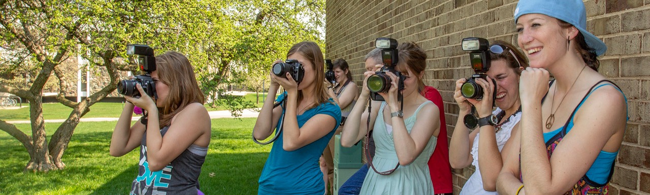 Students photographing in the shade of a building